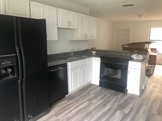 a kitchen with black appliances and white cabinets