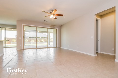 A spacious room with a ceiling fan and sliding glass doors.