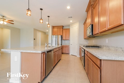 A kitchen with wooden cabinets and a marble countertop.
