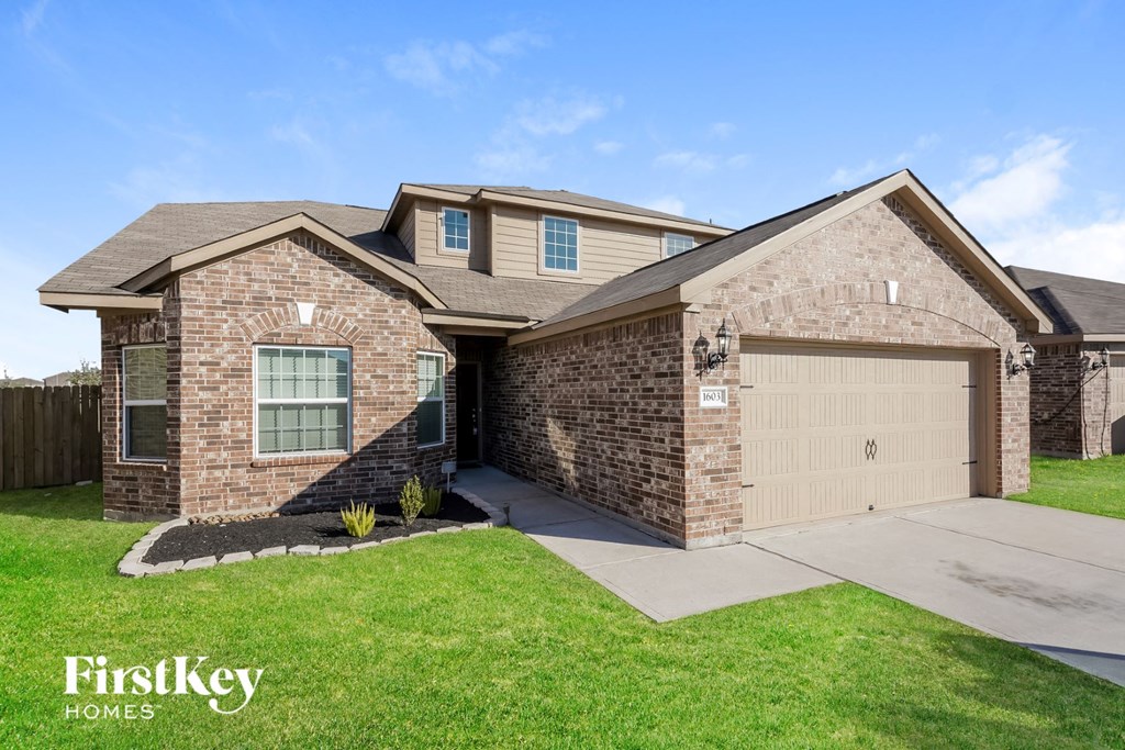 A brick house with a garage door that says "FirstKey Homes".