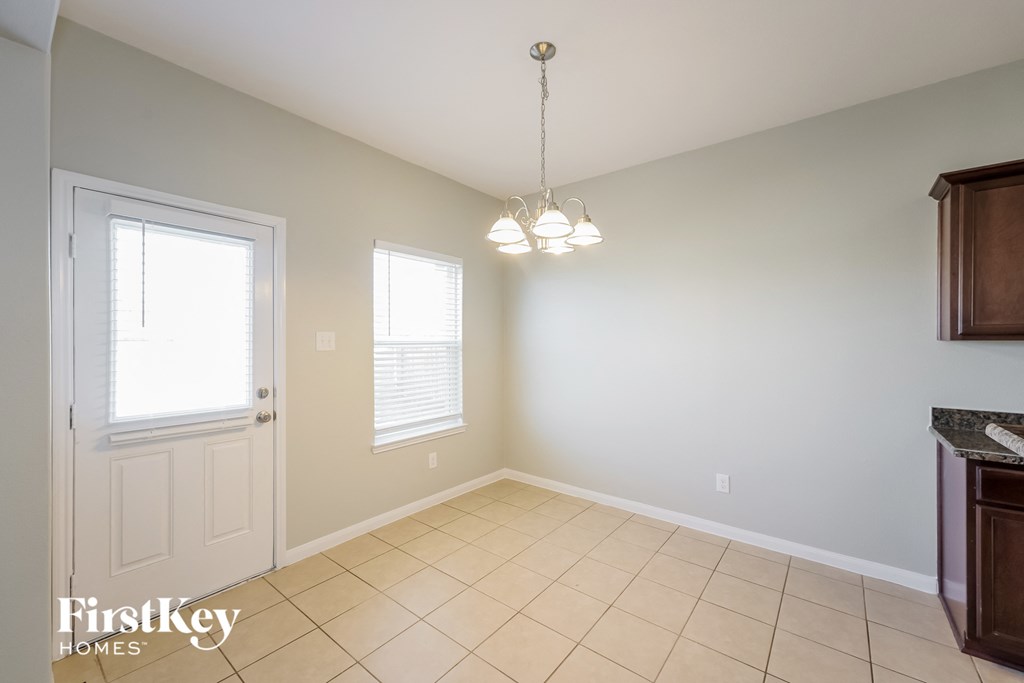 A room with a door, a window, and a chandelier.