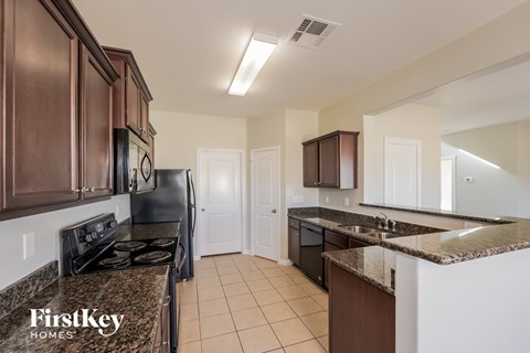 A kitchen with a black stove top oven and a black dishwasher.