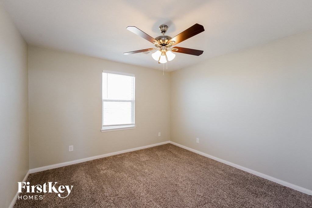 A room with a ceiling fan and a window.