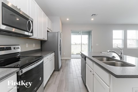 A modern kitchen with white cabinets and stainless steel appliances.
