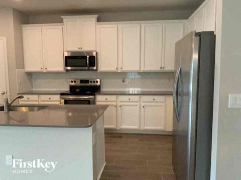 a kitchen with white cabinets and a stainless steel refrigerator