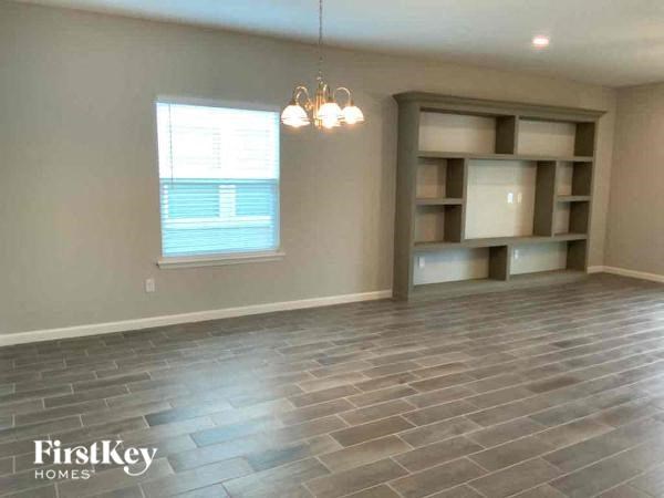 an empty living room with tile flooring and a window