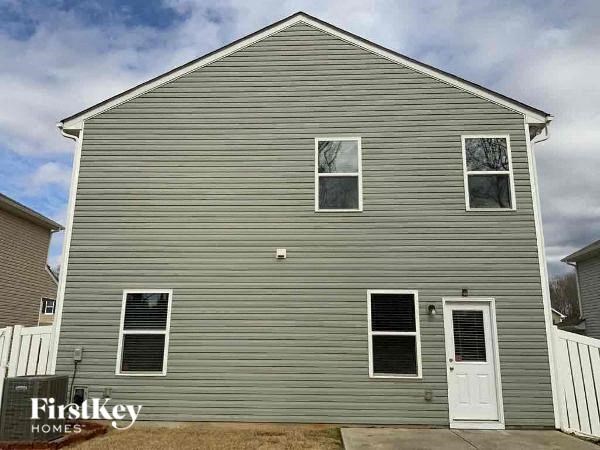 the front of a gray house with a white door