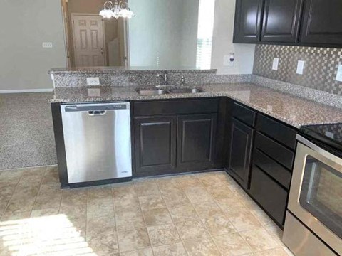 a kitchen with black cabinets and a stainless steel dishwasher