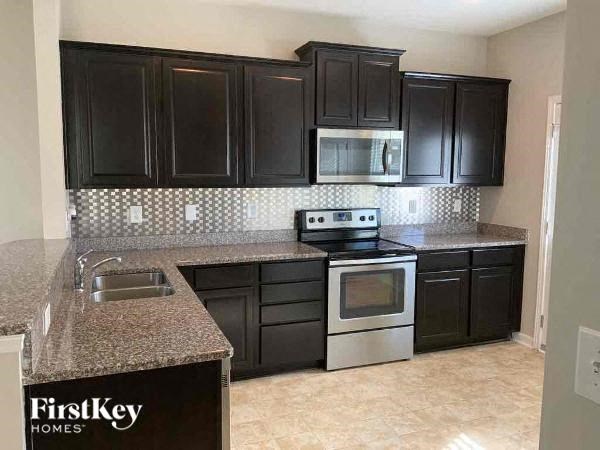 a kitchen with black cabinets and stainless steel appliances