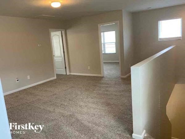 an empty living room with a carpeted floor