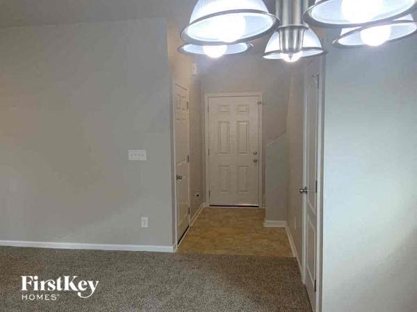 a hallway with a white door and ceiling lights