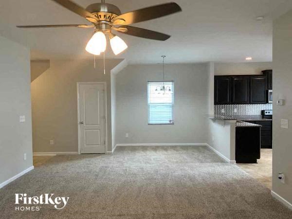 an empty living room with a ceiling fan