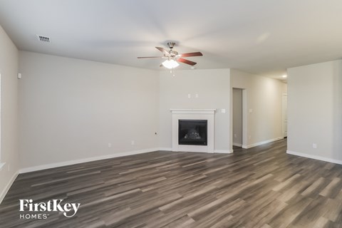 a living room with a fireplace and a ceiling fan