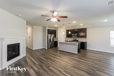 a kitchen and living room with wood flooring and a fireplace