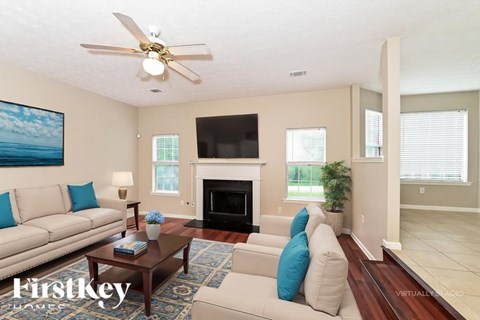 A living room with a fireplace and a painting of the ocean on the wall.