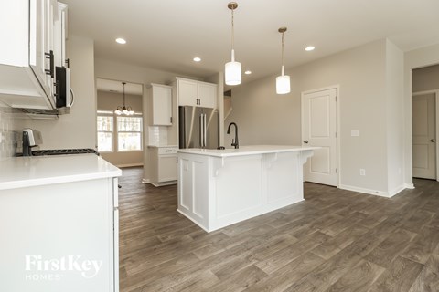 A kitchen with a white counter and wooden floors.