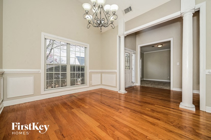 A room with wooden floors and a chandelier.