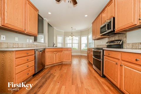 A kitchen with wooden cabinets and a FirstKey Homes logo.