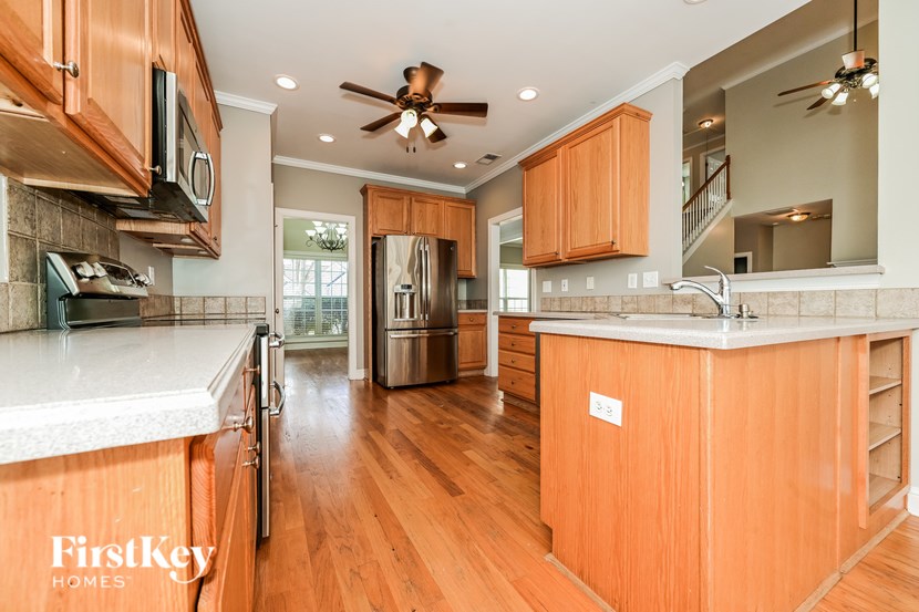 A kitchen with wooden cabinets and a ceiling fan.
