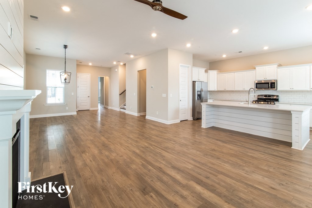 A spacious living room with wooden floors and a fireplace.