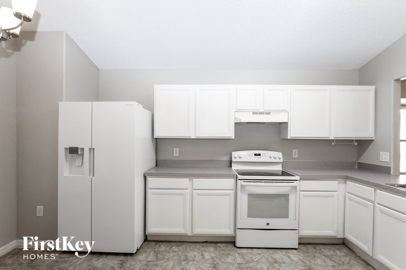 A kitchen with white appliances and cabinets.