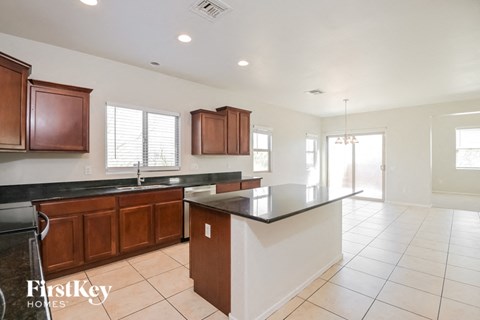 A kitchen with brown cabinets and a black countertop.