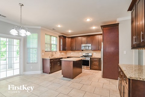 a large kitchen with wooden cabinets and tile flooring
