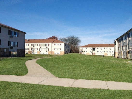a sidewalk leading to a row of apartments