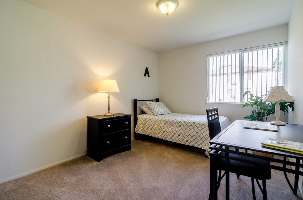 a bedroom with a bed and a dining room table and a window