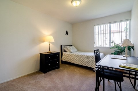 a bedroom with a bed and a dining room table and a window