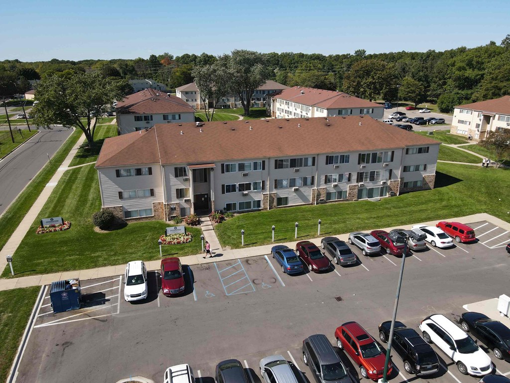 an aerial view of a building with cars parked in a parking lot