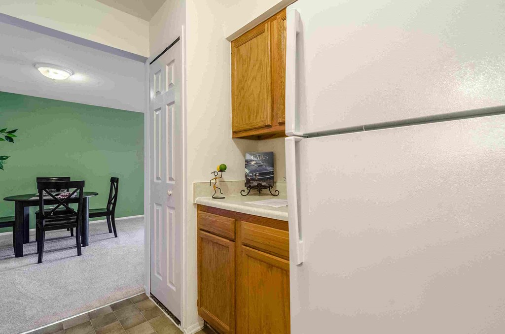 a kitchen with a refrigerator and a dining room table