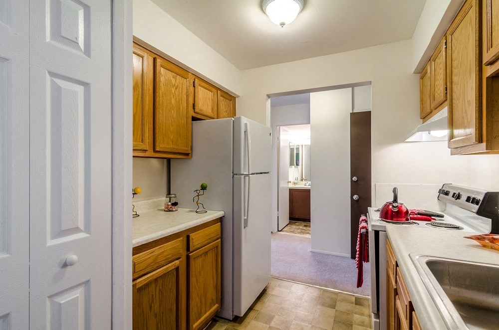 a kitchen with a refrigerator and a sink      and a door