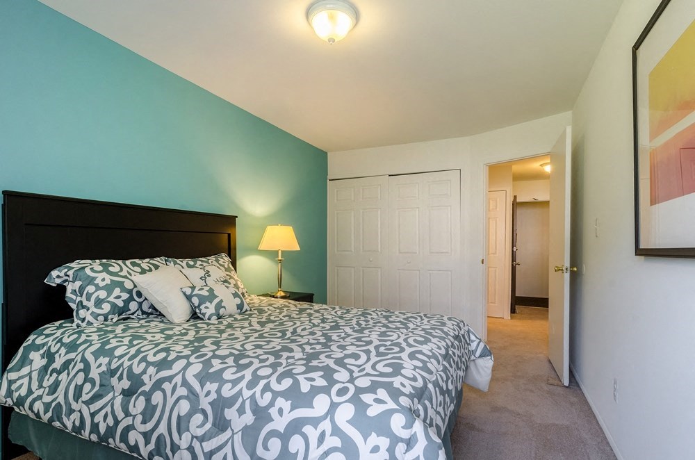 a bedroom with a bed and a door to a bathroom