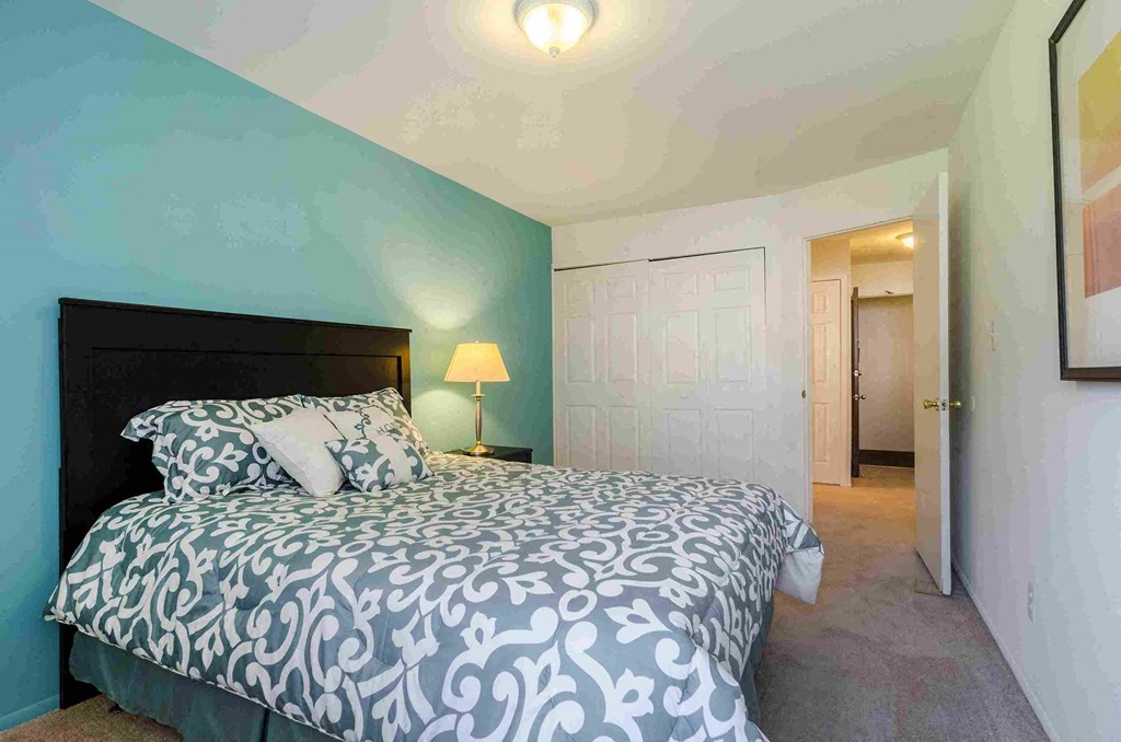 a bedroom with a bed and a door to a bathroom