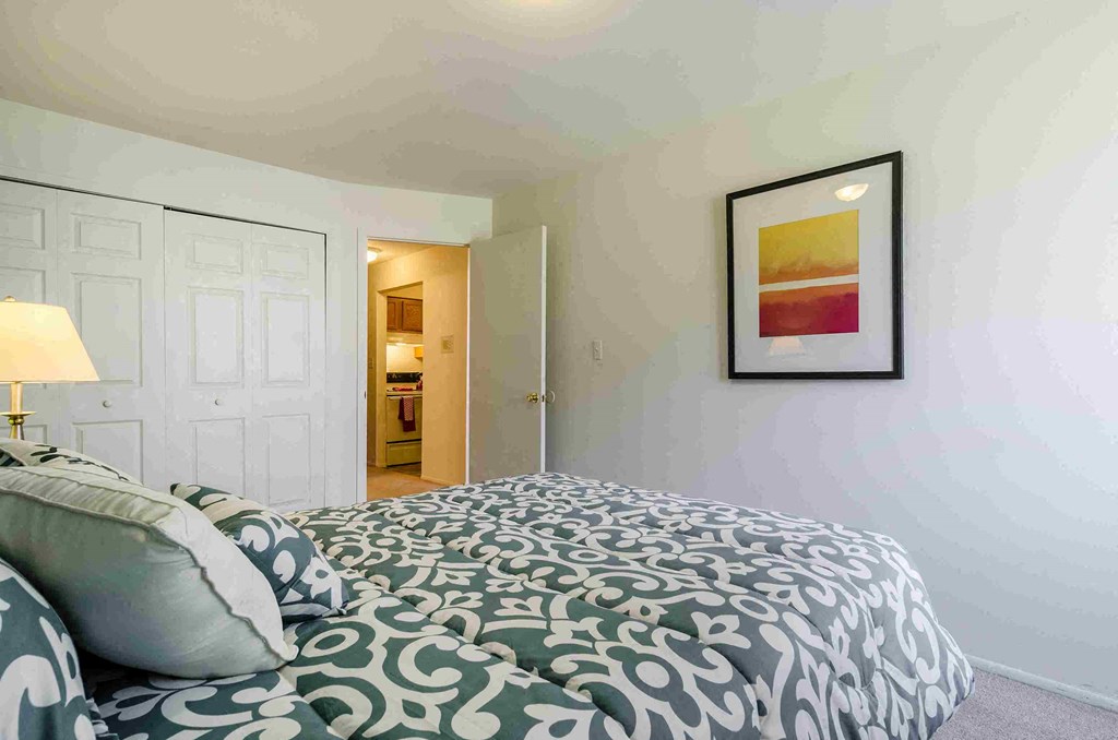 a bedroom with a bed and a door to a bathroom