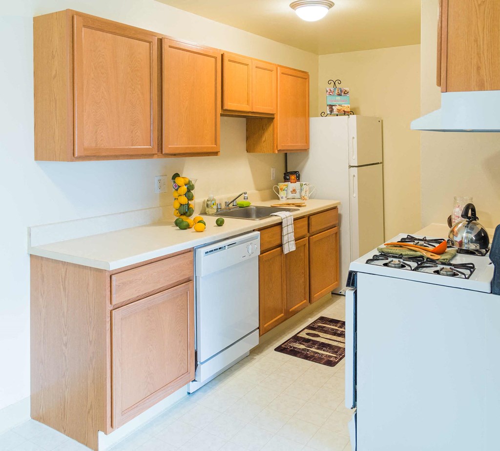 a kitchen with white appliances and wooden cabinets