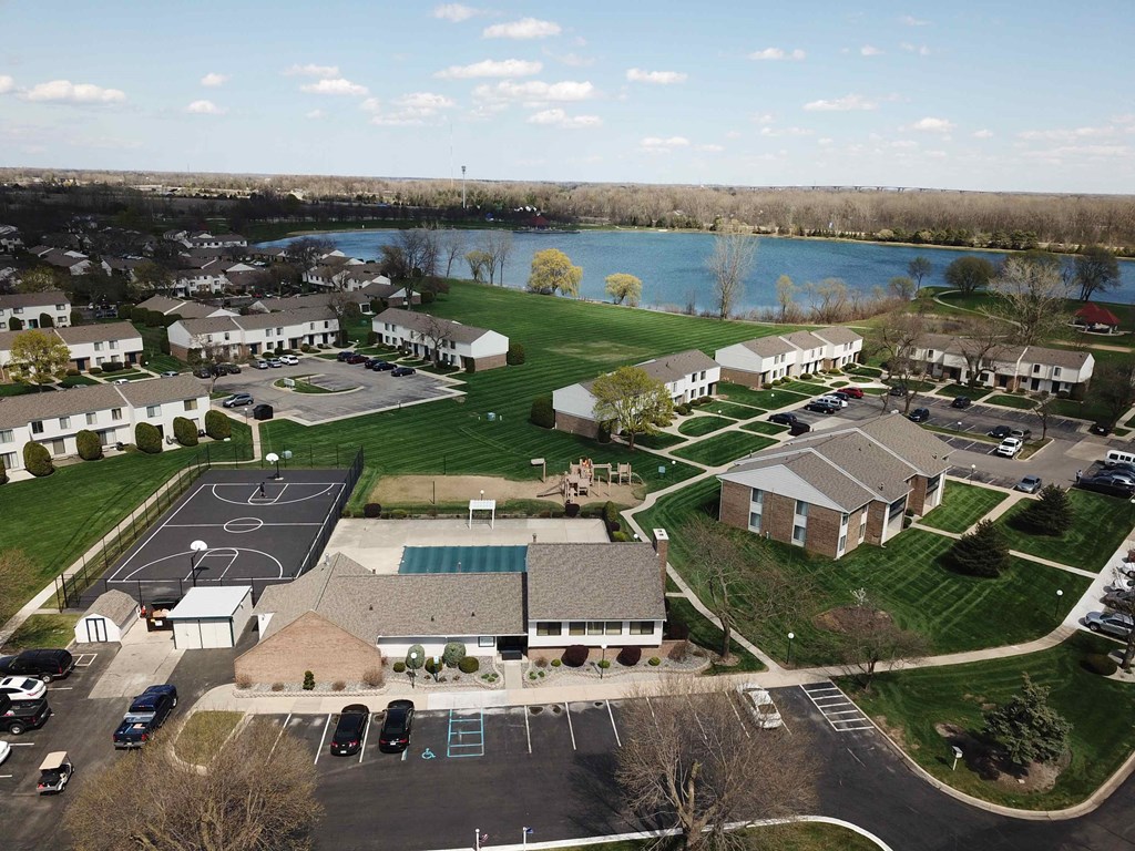 an aerial view of a neighborhood of houses with a lake in the background