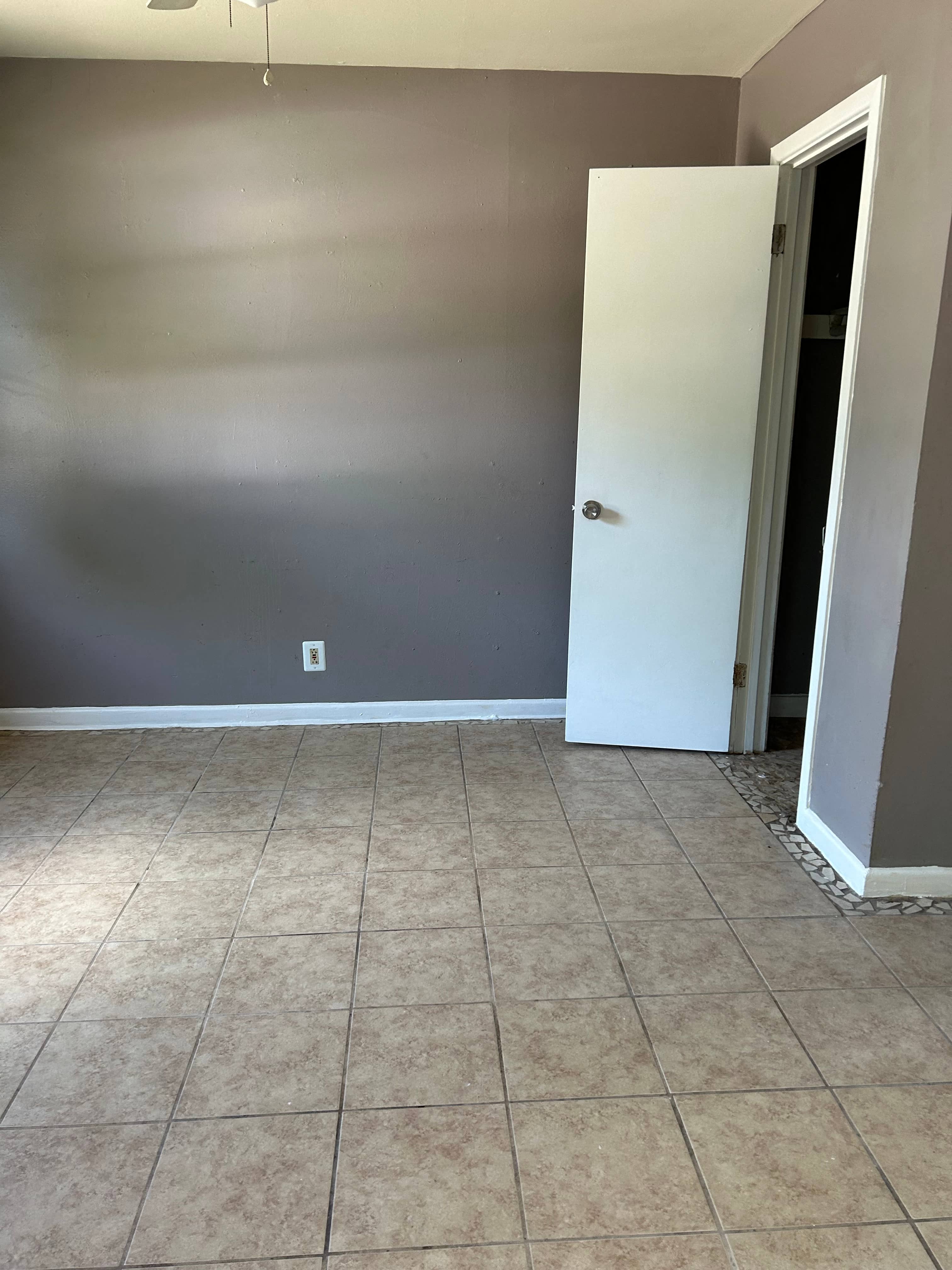 an empty room with a tiled floor and a door