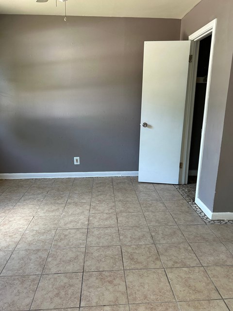 an empty room with a tiled floor and a door