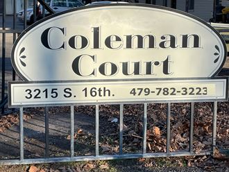 a sign for colman court in front of a gate