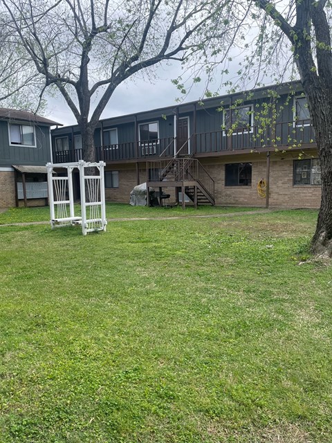 A white gate stands in a grassy yard.