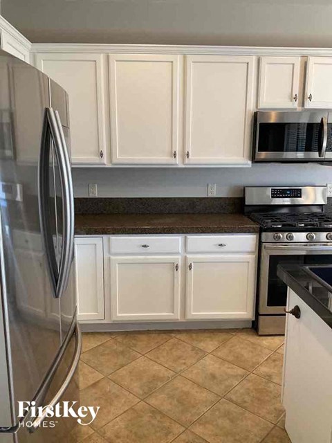 a kitchen with white cabinets and stainless steel appliances