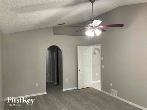 a living room with a ceiling fan and a white door