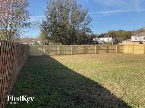 a fenced in backyard with a fence and grass