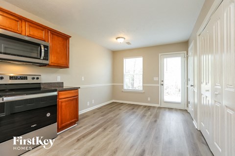 A kitchen with wooden cabinets and a black stove top oven.