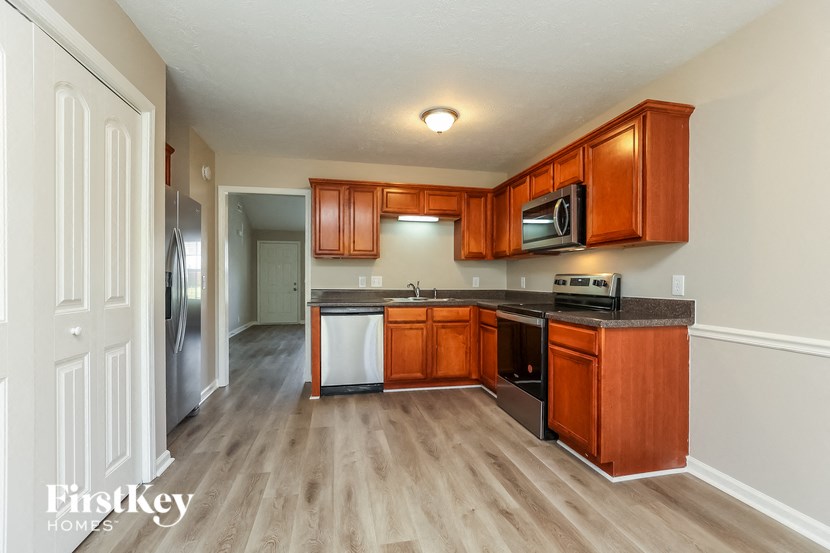 A kitchen with wooden cabinets and a white fridge.