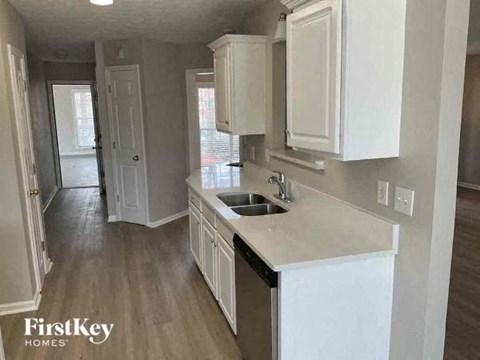 A kitchen with white cabinets and a sink.