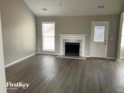 A living room with a fireplace and a door on the right.