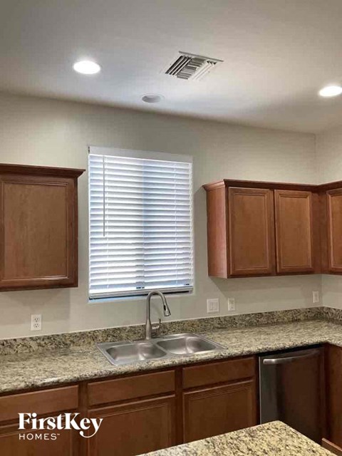 a kitchen with wooden cabinets and a sink and a window